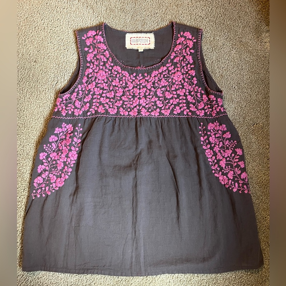 Dark purple top with lighter and brighter purple embroidered flowers.